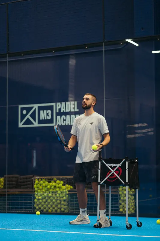 Coach de M3 con la cesta de pelotas durante un entrenamiento individual